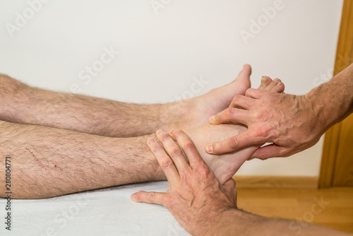 Doctor physiotherapist assisting a male patient while cuboides check of patient in a physio room, rehabilitation physiotherapy concept.