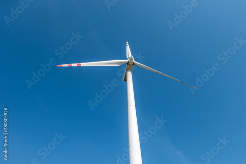 rotating blades of a windmill propeller on blue sky background. Wind power generation. Pure green energy. © hiv360