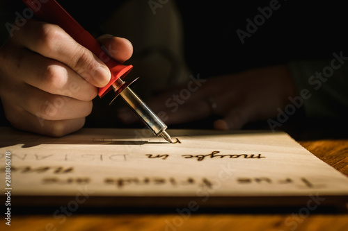 Person Burning Words onto a Piece of Wood