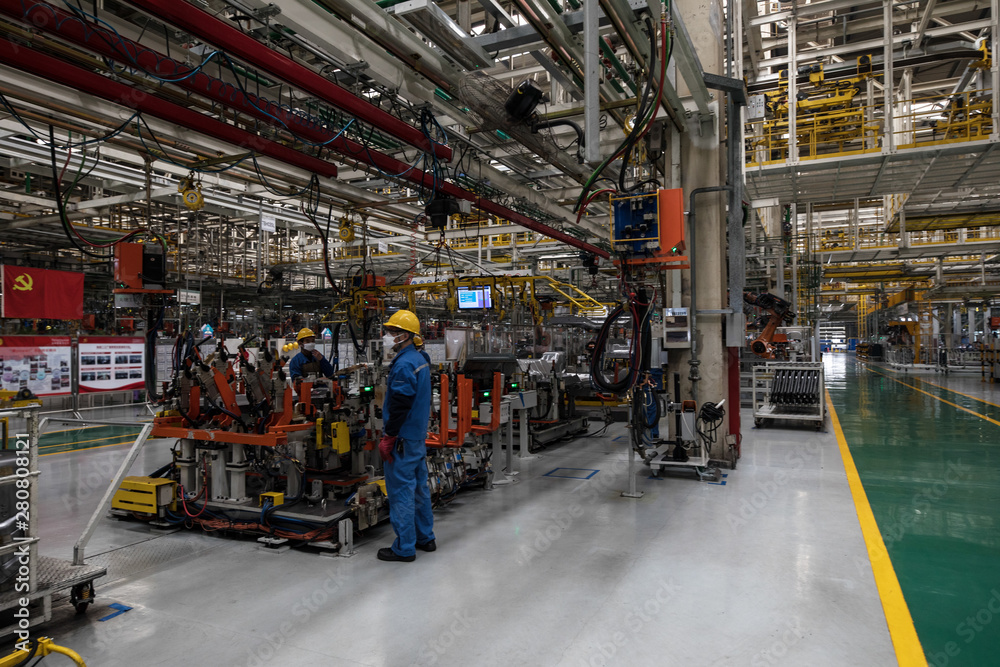 Fototapeta premium Workers in machinery factory in China.