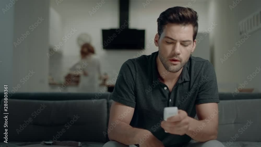 Handsome man looking for tv program at kitchen. Smiling guy making win gesture Handsome man looking for tv program at kitchen. Smiling guy making win gesture