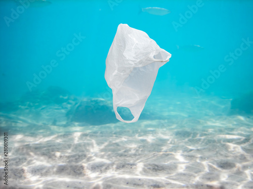 plastic bag drifts in the clear ocean