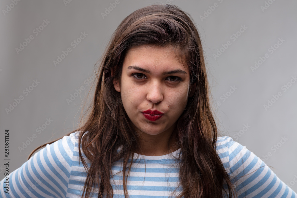 Angry young woman pursing her lips