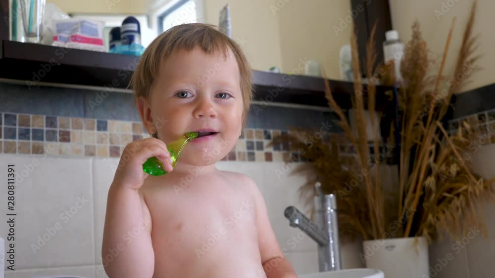 Baby brushing the teeth in bathroom. Stomatology concept. Pediatrics
