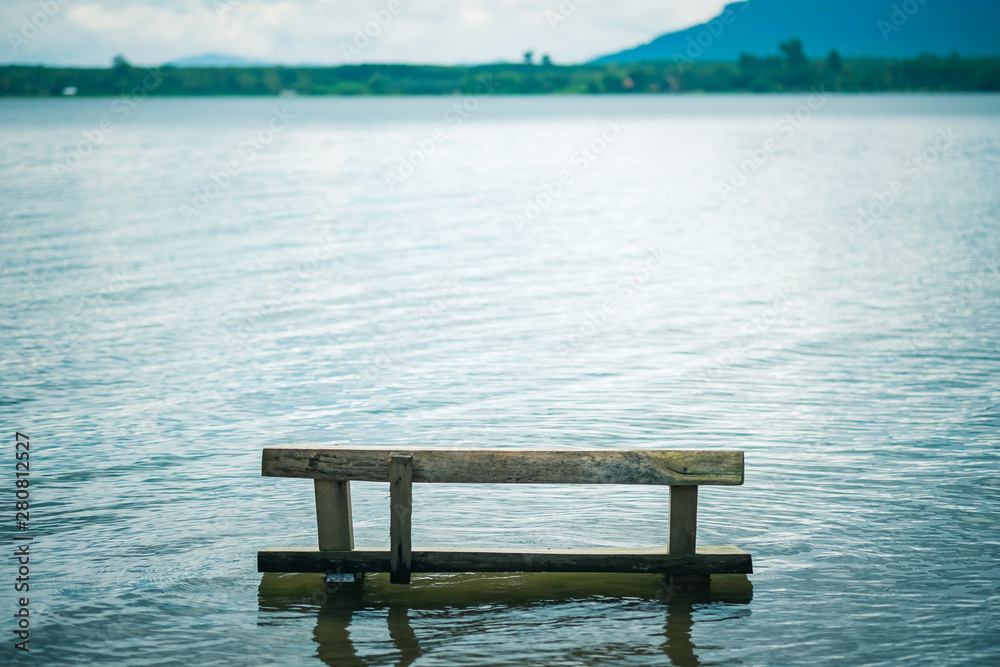 wooden chair on the lake against mountain background