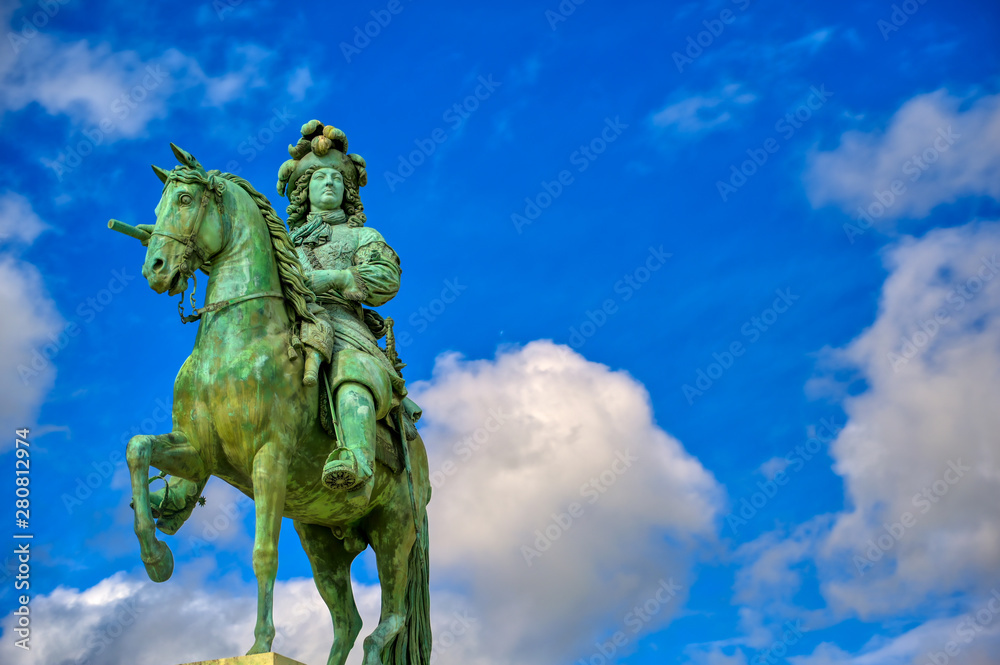 Fototapeta premium Versailles, France - April 24, 2019: Louis XIV statue just outside of the gates of Versailles Palace on a sunny day outside of Paris, France.