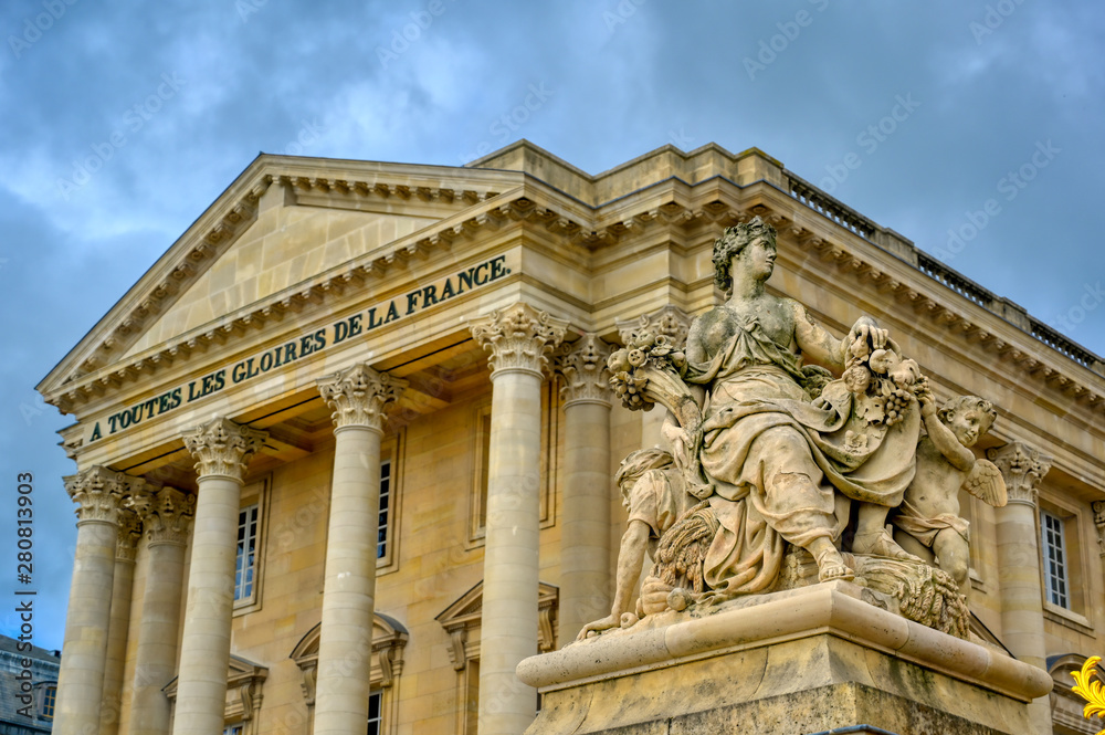 Obraz premium Versailles, France - April 24, 2019: The statues and fountains in and around the garden of Versailles Palace on a sunny day outside of Paris, France.