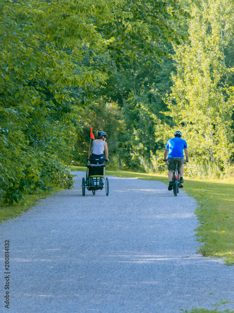 Couple are cycling in the park during the  summer time.