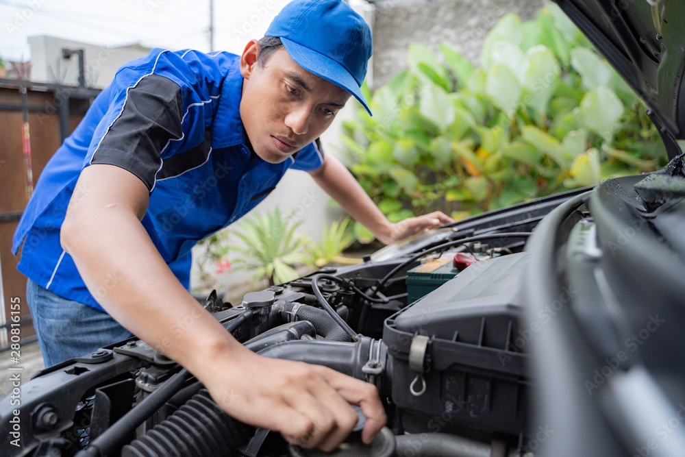 home service mechanic doing some inspection on car's engine home service mechanic doing some inspection on car's engine