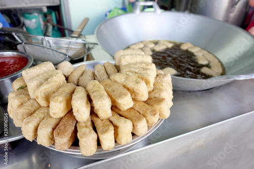 Crispy deep fried tofu after placed on the drying rack for the excess oil to drip off from street vendor at Thai street food vendor market, Vegetarian food, Thai food, snacks Thai style.