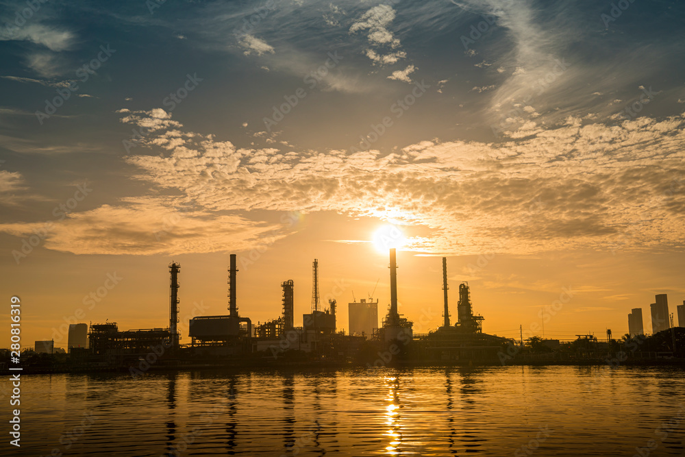 refinery oil petroleum production factory with river reflecting surface sunrise morning sky