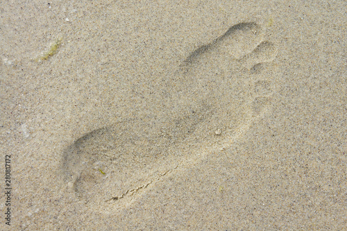 Human footprint on the sandy seashore close up shot