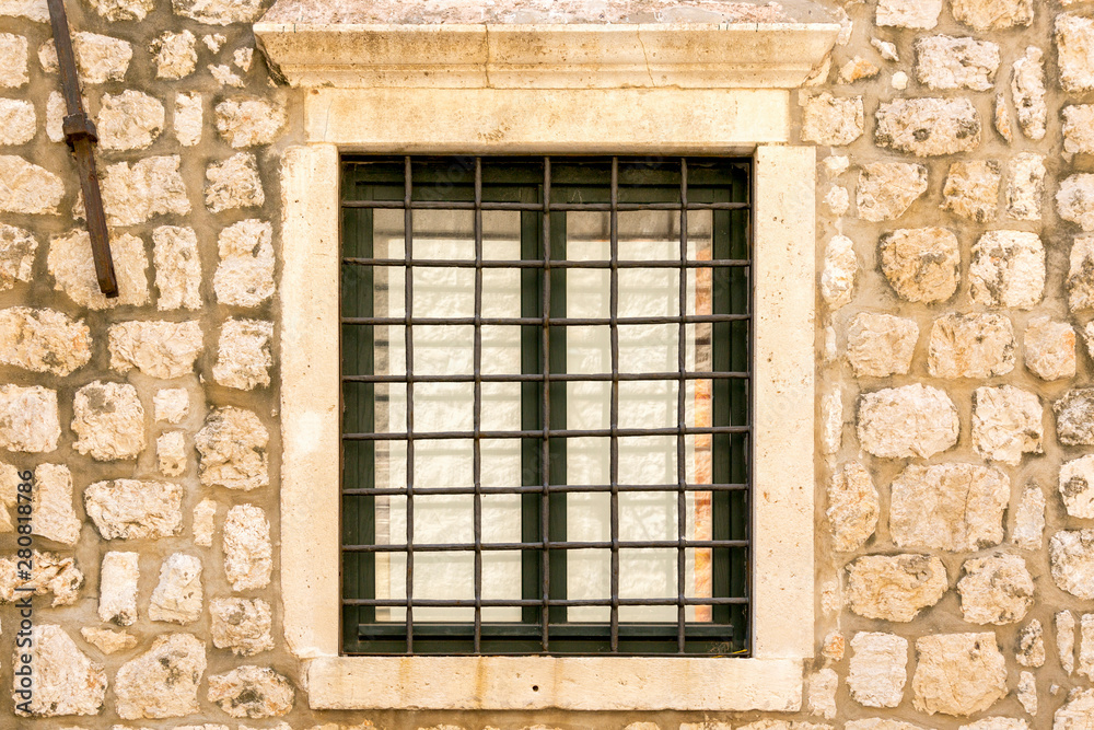 Iron window on the facade of a stone house Iron window on the facade of a stone house