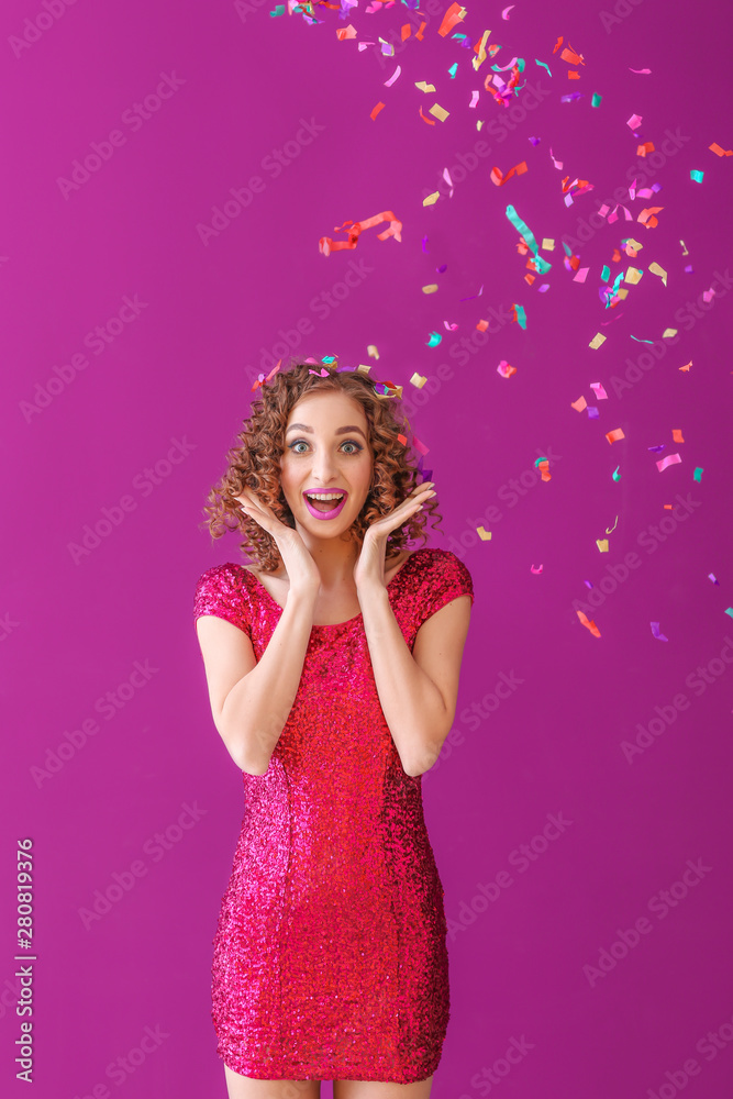 Surprised young woman with confetti on color background Surprised young woman with confetti on color background