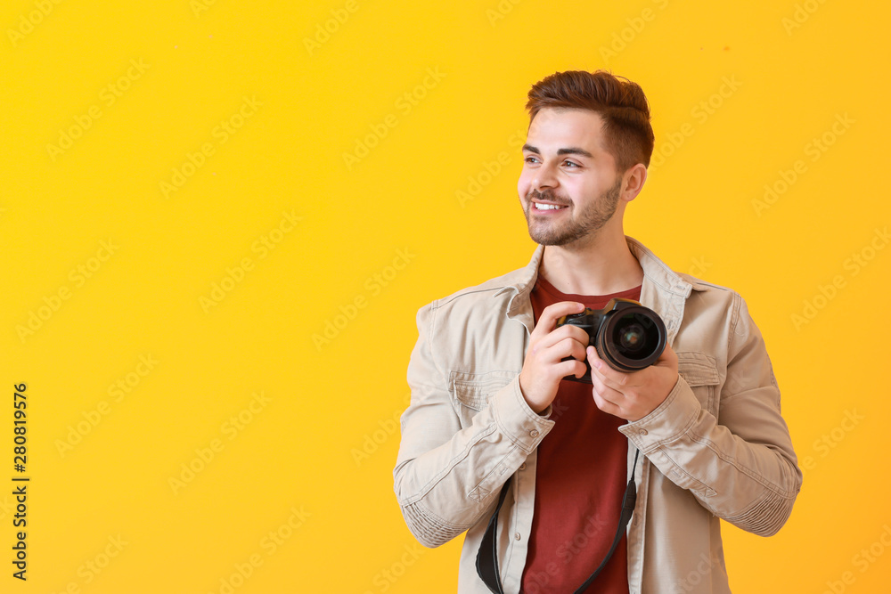 Young male photographer on color background Young male photographer on color background