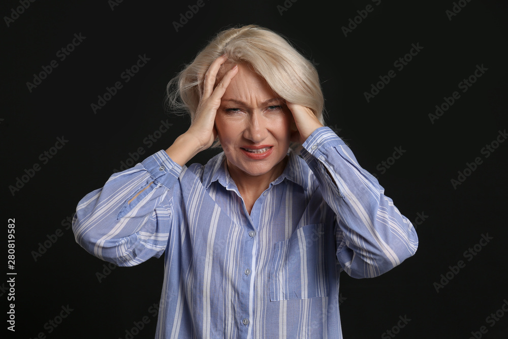 Stressed mature woman on dark background Stressed mature woman on dark background