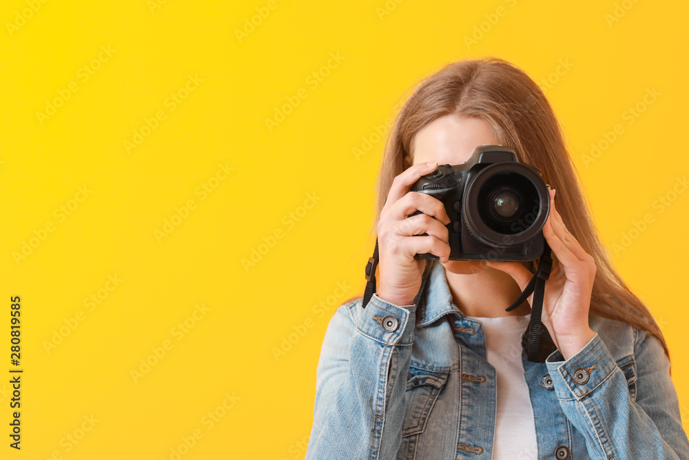 Young female photographer on color background Young female photographer on color background