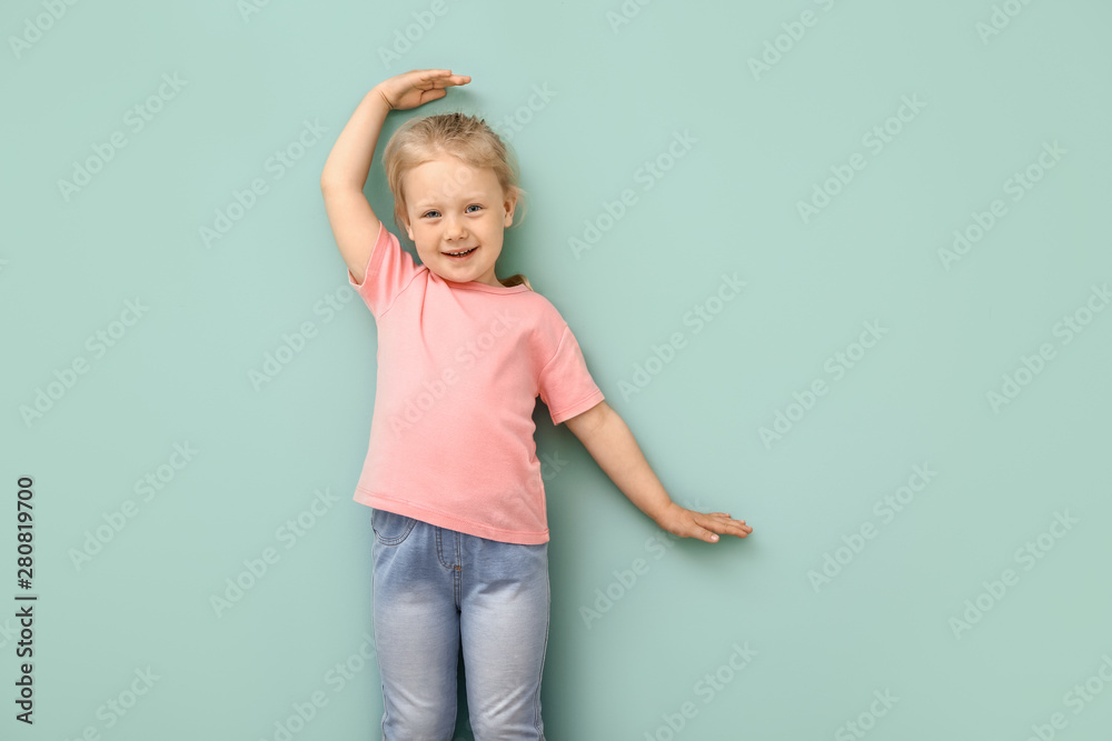 Little girl measuring height near wall Little girl measuring height near wall