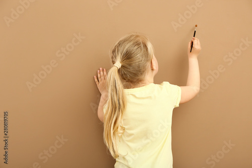 Little girl painting on col...