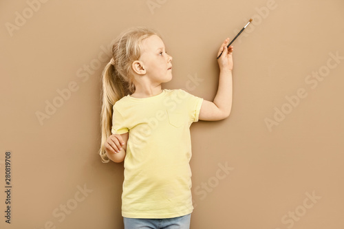 Little girl painting on col...