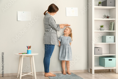 Mother measuring height of ...
