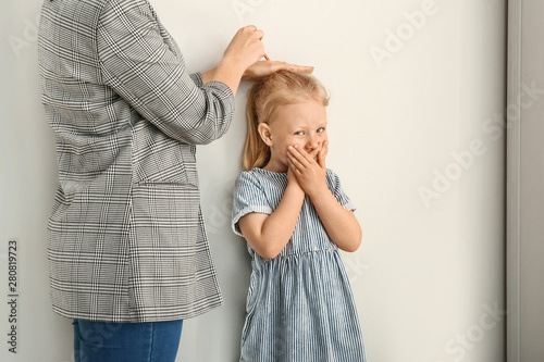 Mother measuring height of ...