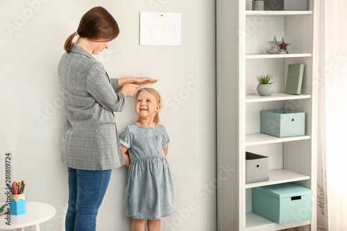 Mother measuring height of ...