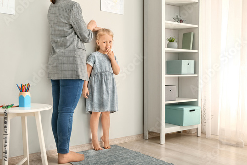 Mother measuring height of ...