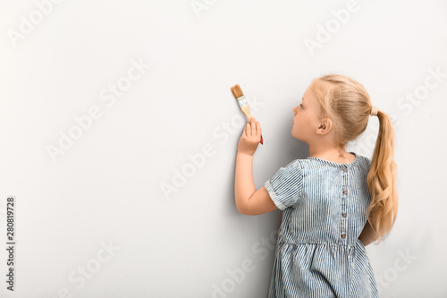 Little girl painting on lig...