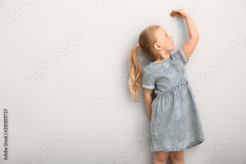 Little girl measuring heigh...