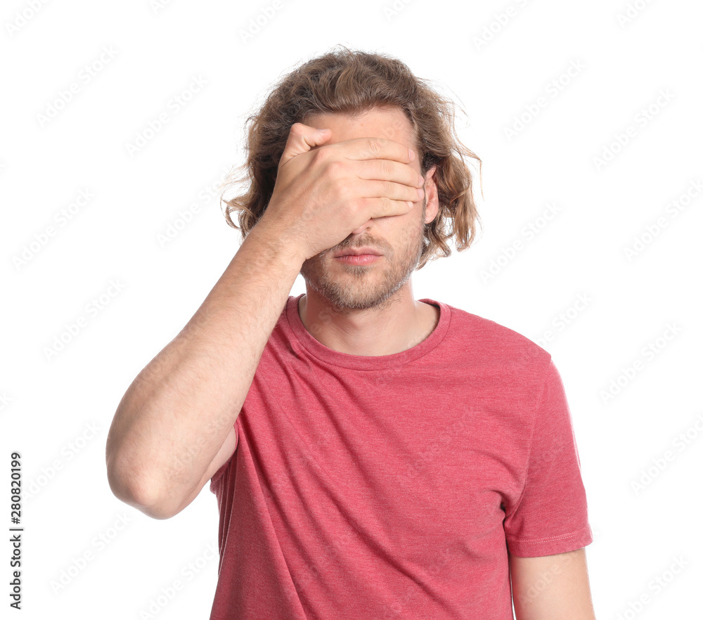 Young man covering his eyes on white background Young man covering his eyes on white background