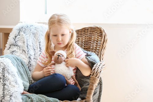 Sad little girl sitting in ...