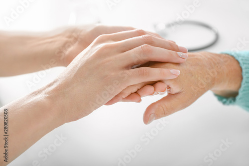 Doctor supporting elderly woman in clinic  closeup