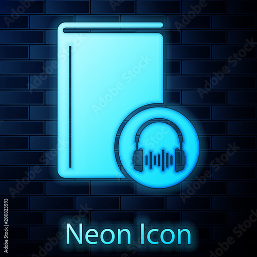 Glowing neon Audio book icon isolated on brick wall background. Book with headphones. Audio guide sign. Online learning concept. Vector Illustration