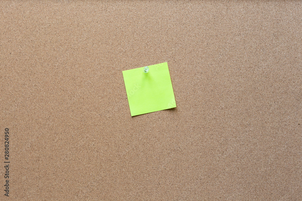 sticky note with tack on a cork bulletin board sticky note with tack on a cork bulletin board