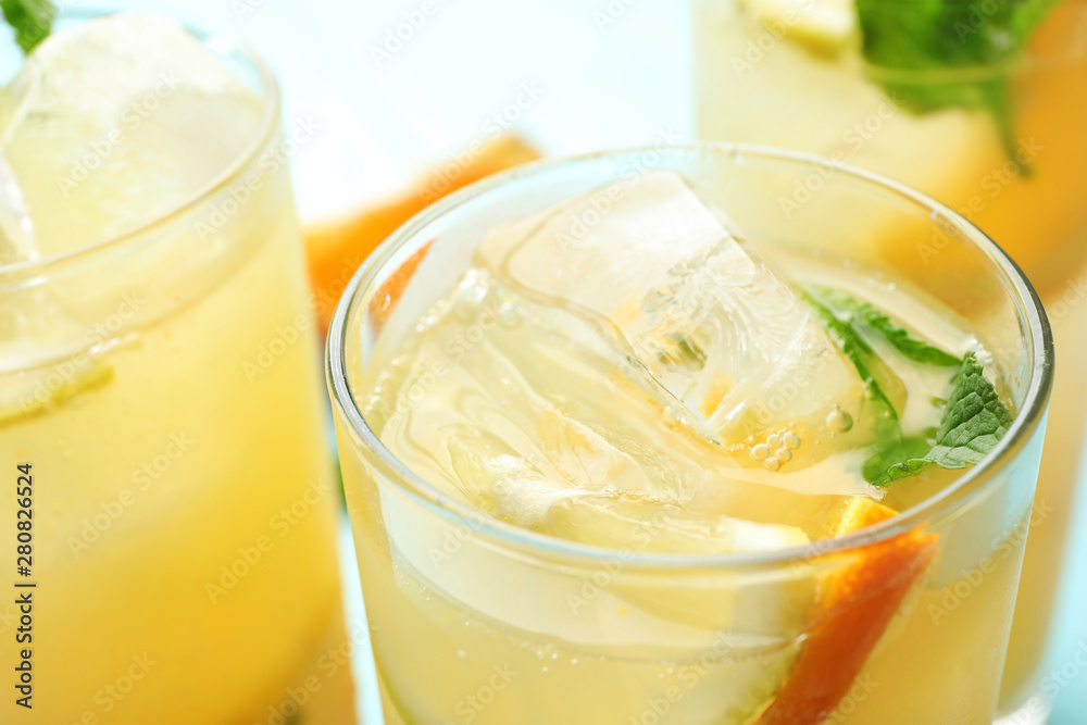 Glasses of citrus refreshing drink with ice cubes and mint, closeup Glasses of citrus refreshing drink with ice cubes and mint, closeup