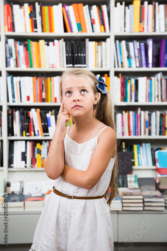 lond girl surprised chooses a book in the library