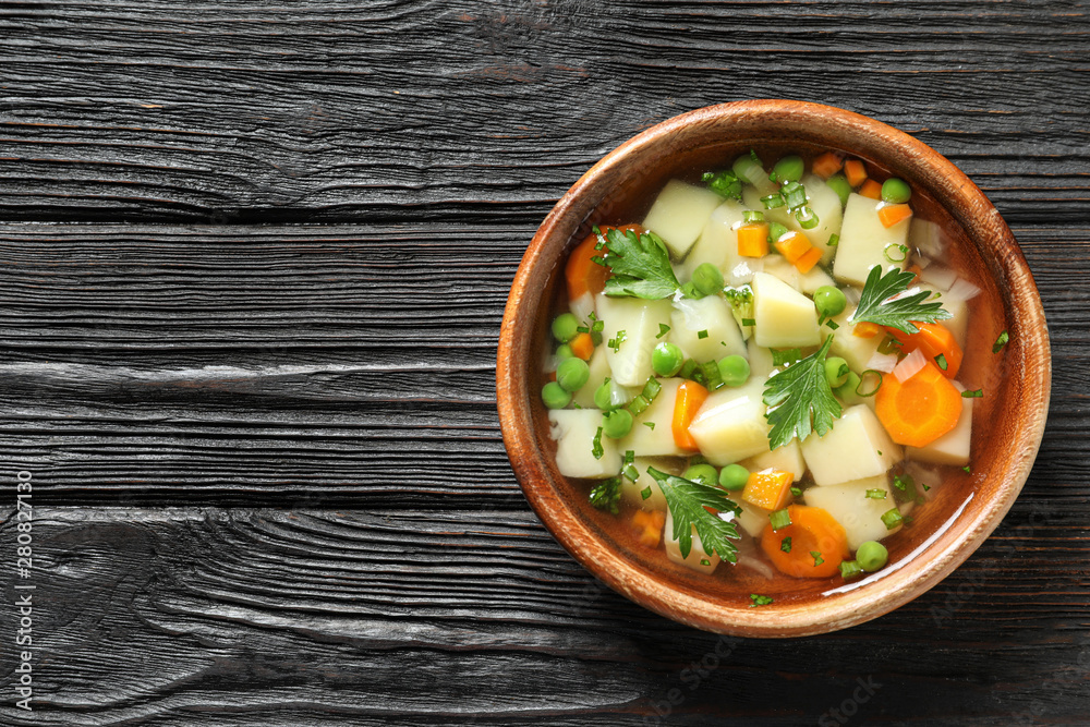 Close up view of a wooden table with a fresh, ready-to-eat homemade  vegetable soup. Stock Photo by lucigerma