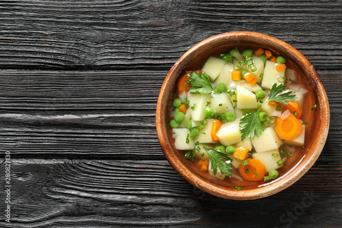 Φωτογραφία Bowl of fresh homemade vegetable soup on dark wooden background, top view