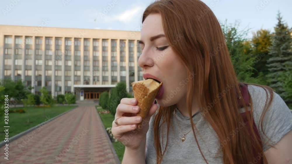 Redhead girl eats tasty ice cream Redhead girl eats tasty ice cream