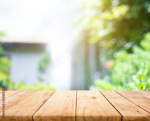 Empty wood table top on blur abstract green from garden and home area background
