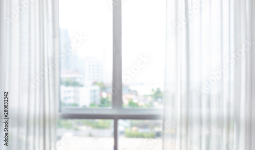 Blur of white curtain on window with city view background