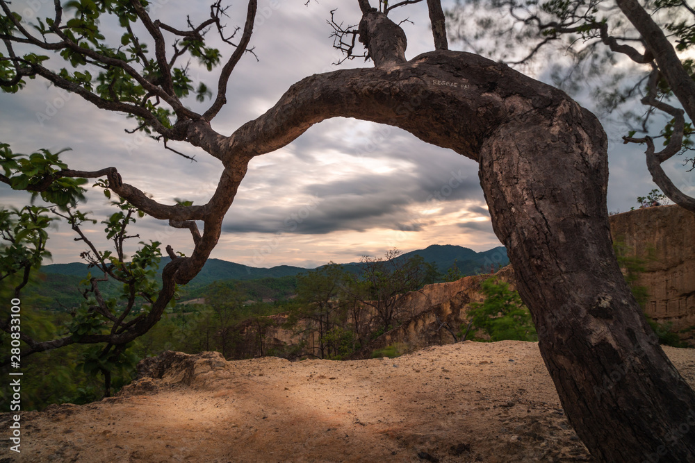 Pai canyon in thailand north in late afternoon golden hour sunset with cloudy sky view from an ancient tree over the valley Pai canyon in thailand north in late afternoon golden hour sunset with cloudy sky view from an ancient tree over the valley