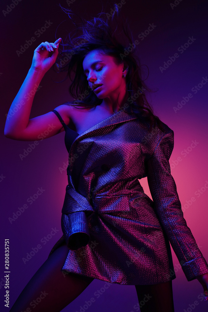 Women style. Fashion model in stylish dress in neon lights