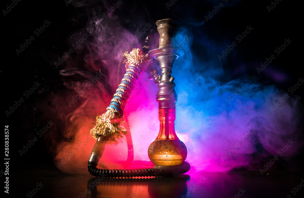 Hookah hot coals on shisha bowl on dark foggy background. Stylish