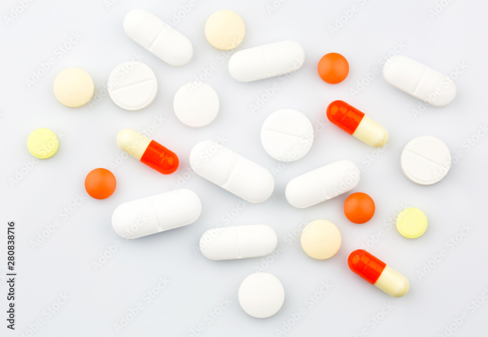 Pharmacy theme. Pills and Capsules on the White Surface. Closeup.