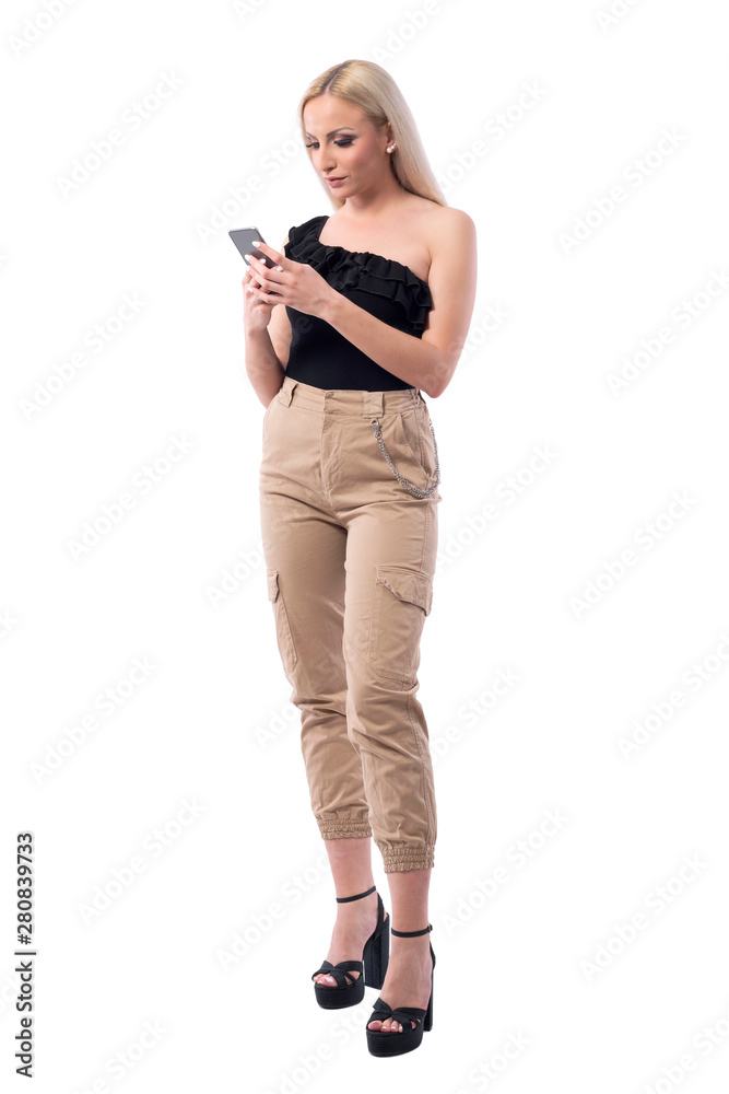 Relaxed young stylish fashion woman using social media on smart phone. Full body isolated on white background. Relaxed young stylish fashion woman using social media on smart phone. Full body isolated on white background.