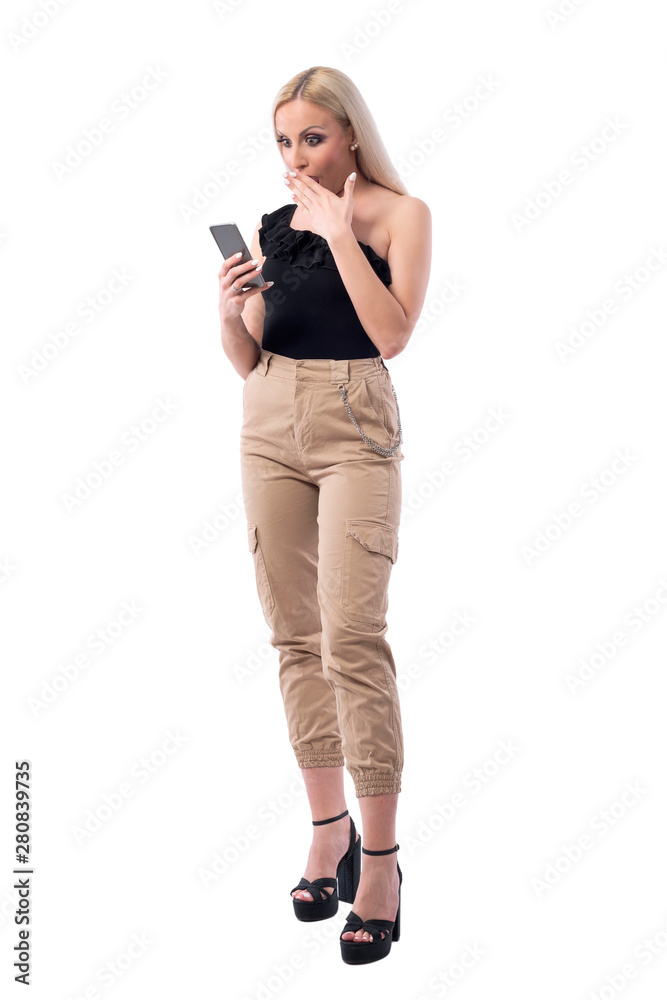 Surprised and shocked woman browsing discount on shopping smartphone app. Full body isolated on white background. Surprised and shocked woman browsing discount on shopping smartphone app. Full body isolated on white background.