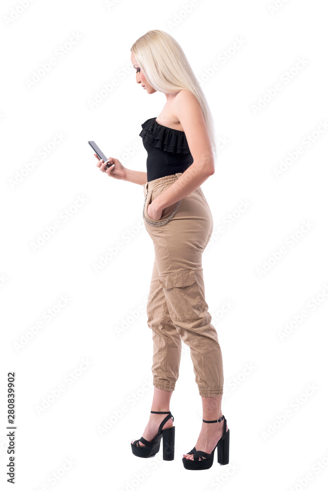 Side view of attractive blonde woman using smart phone reading message. Full body isolated on white background. Side view of attractive blonde woman using smart phone reading message. Full body isolated on white background.