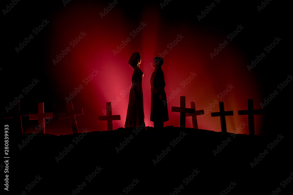 Fototapeta premium Halloween. Scary zombie bride on a night cemetery holds a pumpkin lantern.